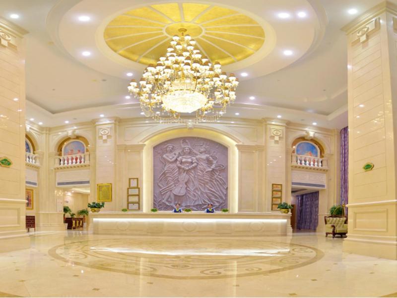 een grote lobby met een kroonluchter in een gebouw bij Vienna International Hotel Meizhou Dingzi Bridge in Meizhou
