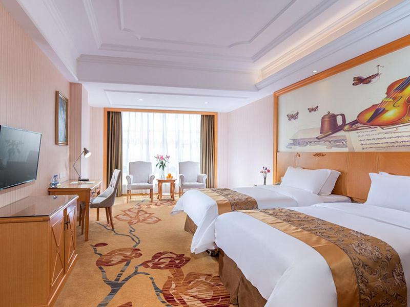 a hotel room with two beds and a flat screen tv at Vienna Hotel Yangjiang Jiangcheng District in Yangjiang