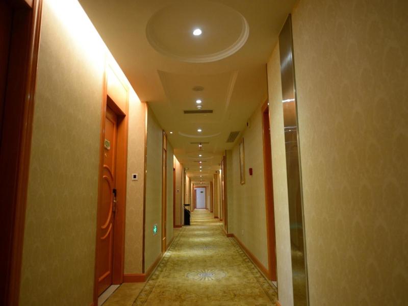 einen Flur mit einem langen Flur mit einem langen Korridor in der Unterkunft Vienna Hotel Shanghai Yangpu Wujiaochang in Shanghai