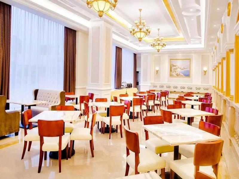 - un restaurant avec des tables et des chaises dans une salle dans l'établissement Vienna International Hotel Changsha Lugu, à Changsha
