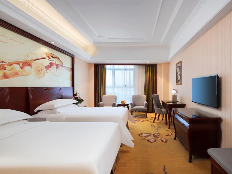 合肥市にあるVienna Hotel Anhui Hefei Sanxiaokouのベッド2台、薄型テレビが備わるホテルルームです。