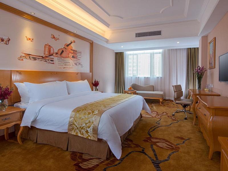 a hotel room with a large bed and a television at Vienna Hotel Foshan Ceramic City in Foshan