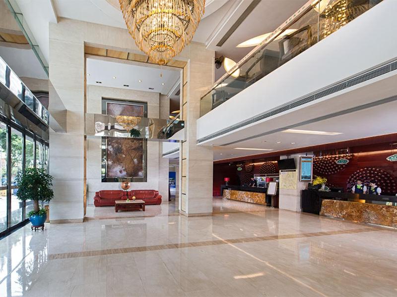 a lobby of a hotel with a couch and a chandelier at Vienna Hotel - Guangzhou South Railway Station Branch in Guangzhou