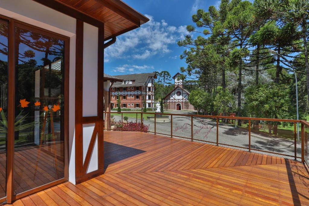 a large deck with a view of a house at Vila Dom Bosco in Campos do Jordão