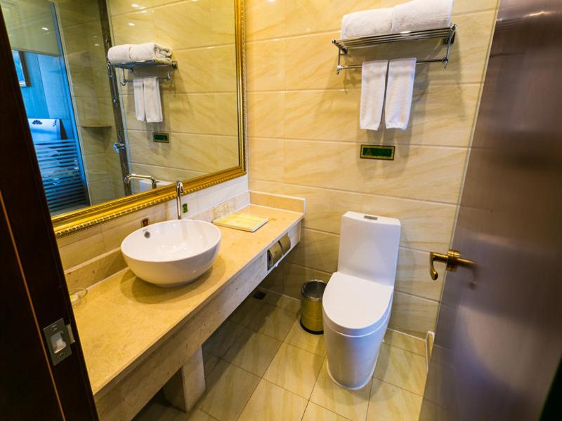 een badkamer met een wastafel, een toilet en een spiegel bij Vienna Hotel Shanghai Hongqiao National Convention and Exhibition Center Wanda in Jiading