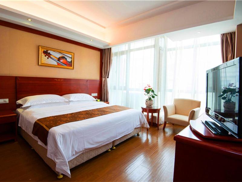 ein Hotelzimmer mit einem großen Bett und einem TV in der Unterkunft Vienna Hotel Shanghai Pudong Airport Huaxia Road in Shanghai
