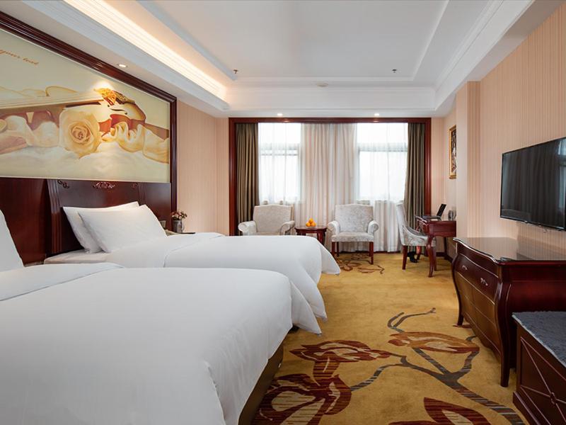 a hotel room with two beds and a flat screen tv at Vienna hotel ( maanshan park post golden eagle international shop) in Ma'anshan