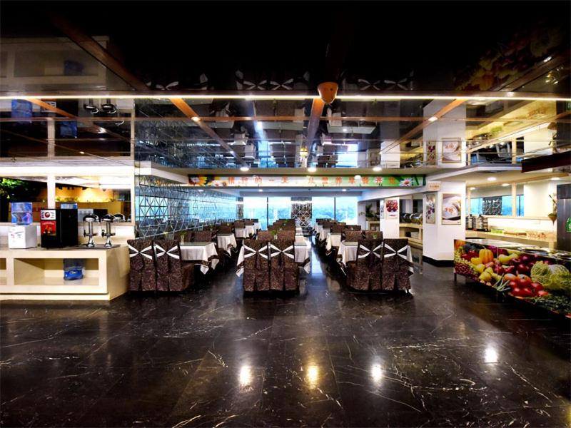長沙市にあるVienna International Hotel Hunan Changsha Time Dijingの店内のテーブルと椅子のあるレストラン
