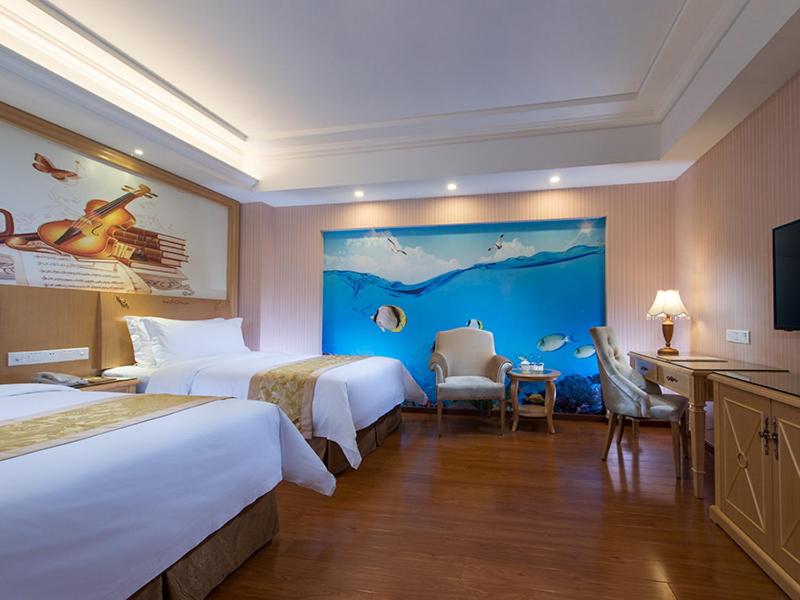 ein Hotelzimmer mit 2 Betten und einem TV in der Unterkunft Vienna 3 Best Hotel Guangzhou Panyu Jinjiang Ave in Guangzhou
