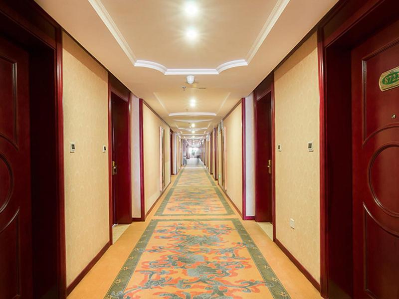 a hallway in a building with a rug on the floor at Vienna Hotel Xinyu Fenyi South Changshan Road in Fenyi