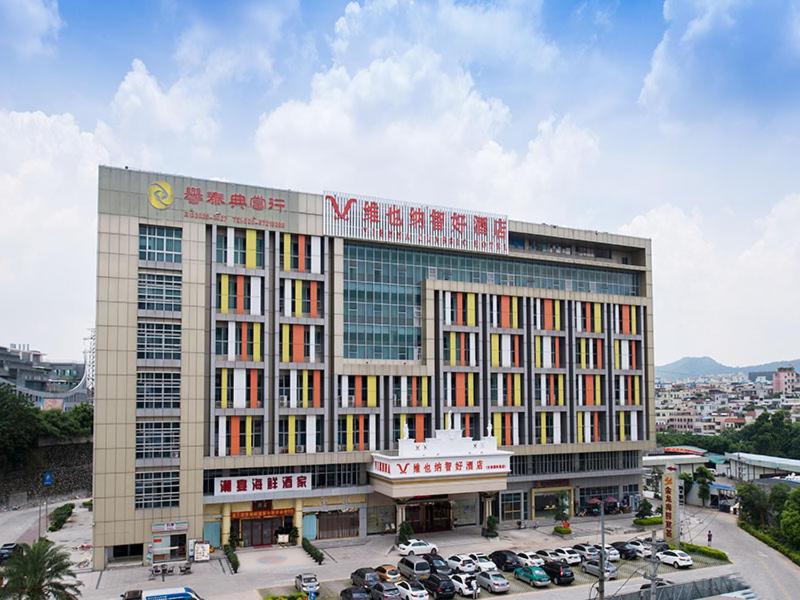 a large building with cars parked in a parking lot at Vienna Classic Hotel Guangzhou Yanling Road in Guangzhou