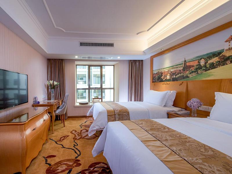een hotelkamer met 2 bedden en een flatscreen-tv bij Vienna Hotel Nanning Gaoxin District in Nanning