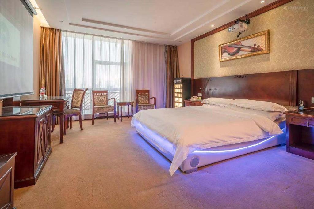 a bedroom with a large bed and a flat screen tv at Vienna Hotel Guangzhou Yuexiu West Huifu Road in Guangzhou