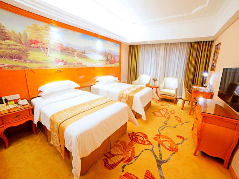 a hotel room with two beds and a television at Vienna Hotel Shaoguan Wuli Pavilion in Shaoguan