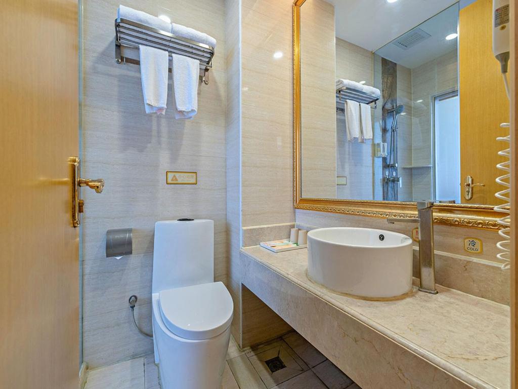 a bathroom with a toilet and a sink and a mirror at Vienna 3 Best Hotel Guangzhou Guangzhou Tower in Guangzhou