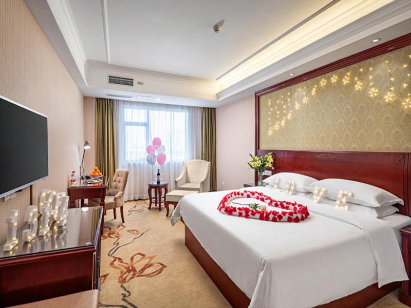 a hotel room with a large bed and a television at Vienna Hotel Guilin North Road in Guilin