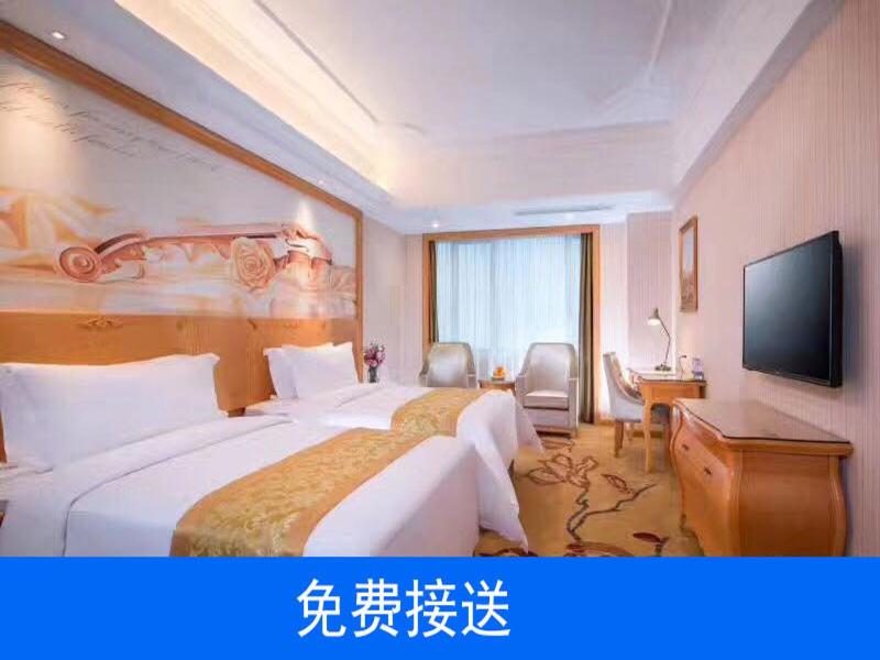 a hotel room with two beds and a flat screen tv at Vienna Hotel Guangzhou South Railway Station in Guangzhou