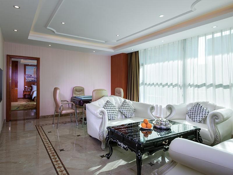 a living room with a white couch and a table at Vienna 3 Best Hotel Shenzhen Pinghu Fumin Road in Longgang