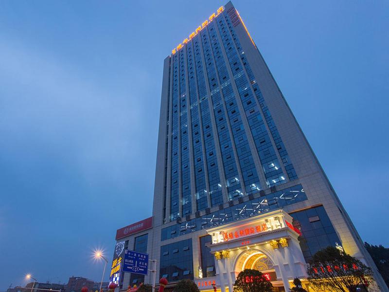 een hoog gebouw met een winkel ervoor bij Vienna International Hotel Changsha Hongxing in Changsha
