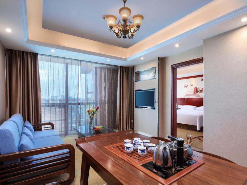 a living room with a blue couch and a table at Vienna Hotel Nanchang Ruzi Road in Nanchang