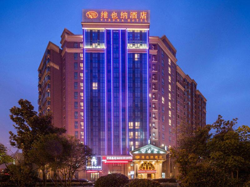 常州市にあるVienna Hotel Jiangsu Changzhou Qingfeng Parkの青いライトが映える大きな建物