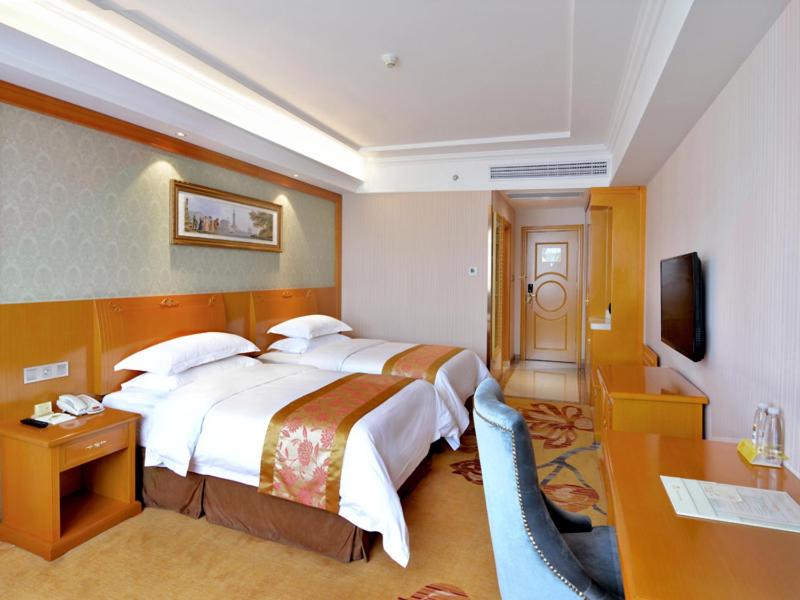 a hotel room with a large bed and a desk at Vienna Hotel Hefei East Changjiang Road in Hefei