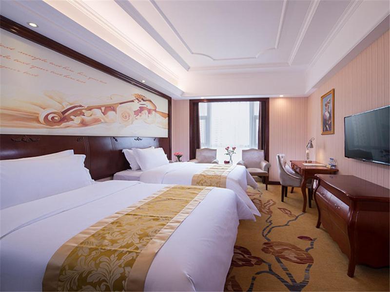 Gaozhou的住宿－維也納酒店廣東高州城東客運站店，酒店客房设有两张床和一台平面电视。