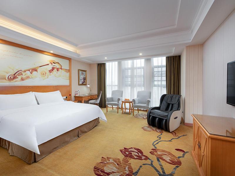 a hotel room with a large bed and a desk at Vienna Hotel Hunan Xincheng Guoji in Liuyang