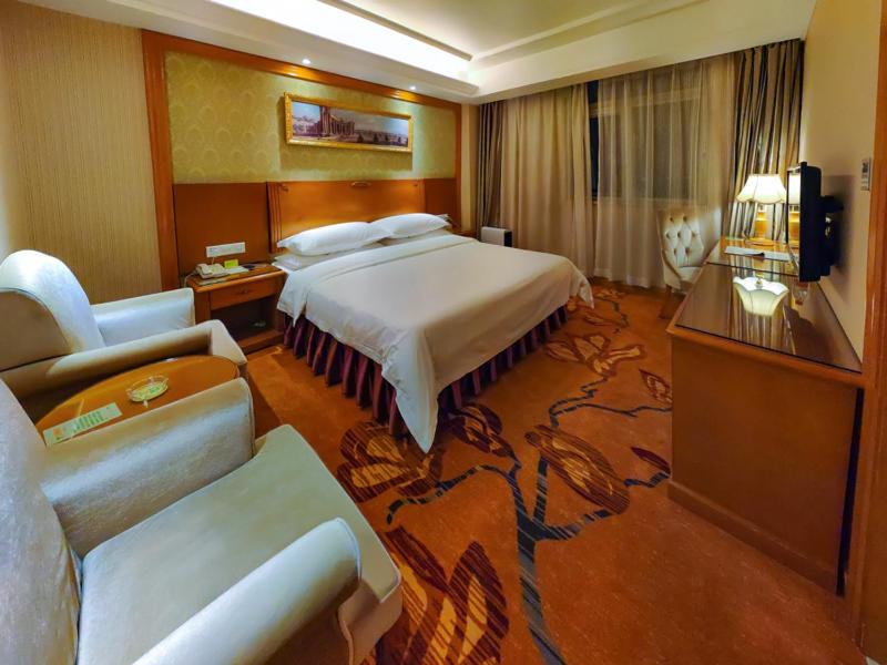 Habitación de hotel con cama y sofá en Vienna 3 Best Hotel Shenzhen Henggang Cuihu Shangzhuang en Longgang