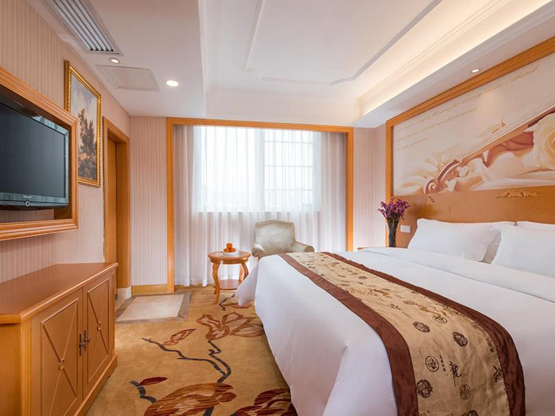 Cette chambre comprend un grand lit et une télévision à écran plat. dans l'établissement Vienna Hotel Shenzhen Dongmen Old Street, à Shenzhen