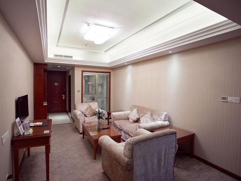 uma sala de estar com dois sofás e uma mesa em Vienna International Hotel Shenzhen Songgang Wanzhao Square em Bao'an