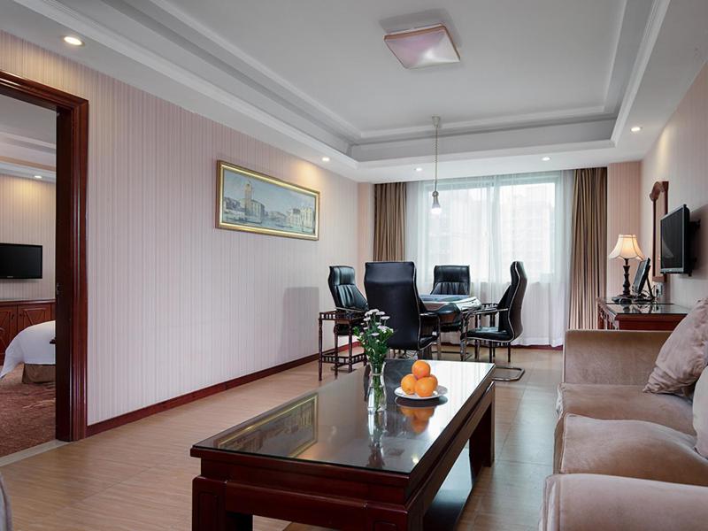 a living room with a couch and a coffee table at Vienna Hotel Huizhou Zhongxin in Huizhou