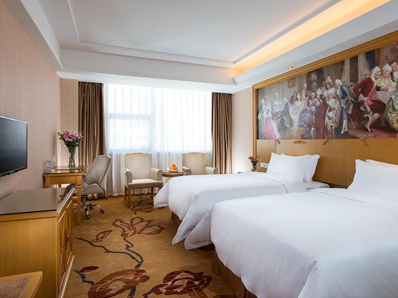 a hotel room with three beds and a flat screen tv at Vienna 3 Best Hotel Shenzhen Longhuadalang Commercial Centre in Bao'an
