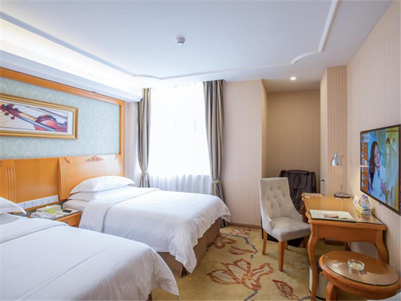 a hotel room with two beds and a desk at Vienna Hotel Guangzhou Nanpu Station in Guangzhou