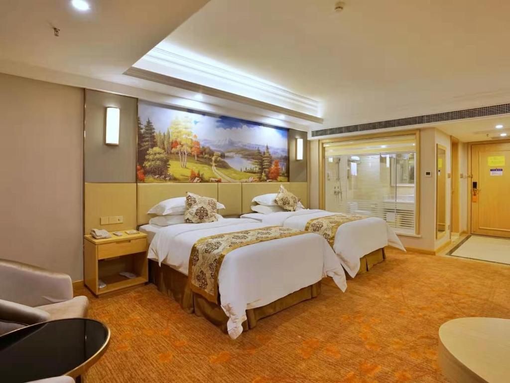 una habitación de hotel con 2 camas y un cuadro en la pared en Vienna International Hotel Nanning Zoo, en Nanning