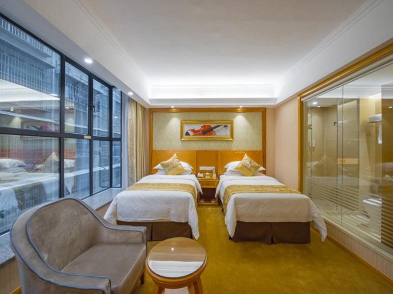 a hotel room with three beds and a couch at Vienna 3 Best Hotel Liuzhou Yuejiang Road in Sanjiang