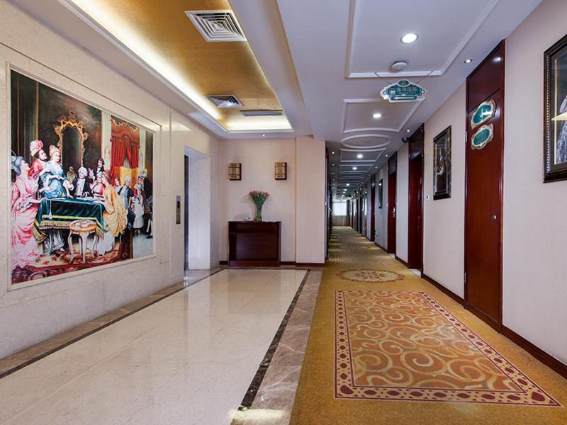 a hallway in a building with a painting on the wall at Vienna Hotel Shenzhen Pingdi in Longgang