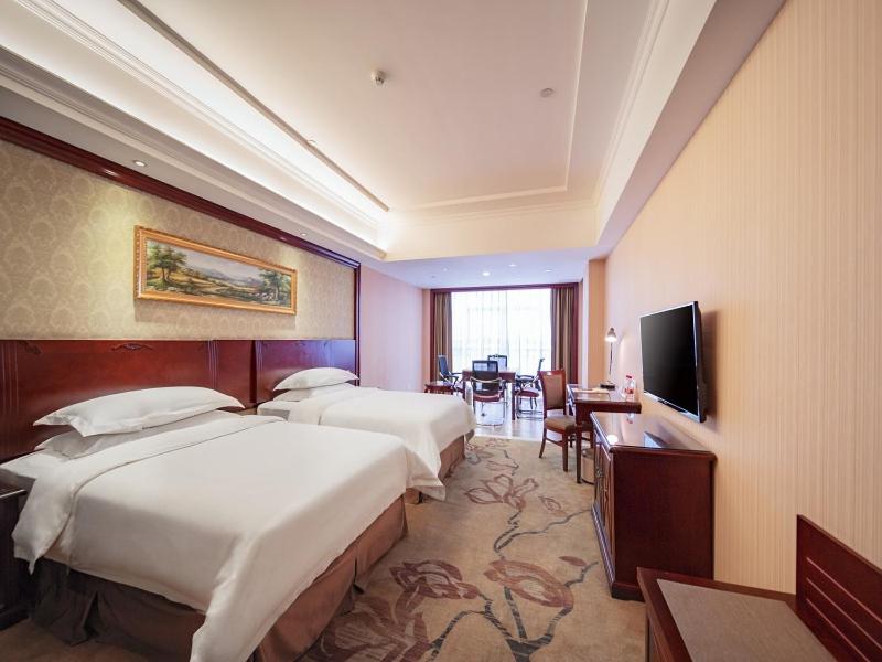 a hotel room with two beds and a flat screen tv at Vienna Classic Hotel Shizhongshan Avenue in Jiujiang