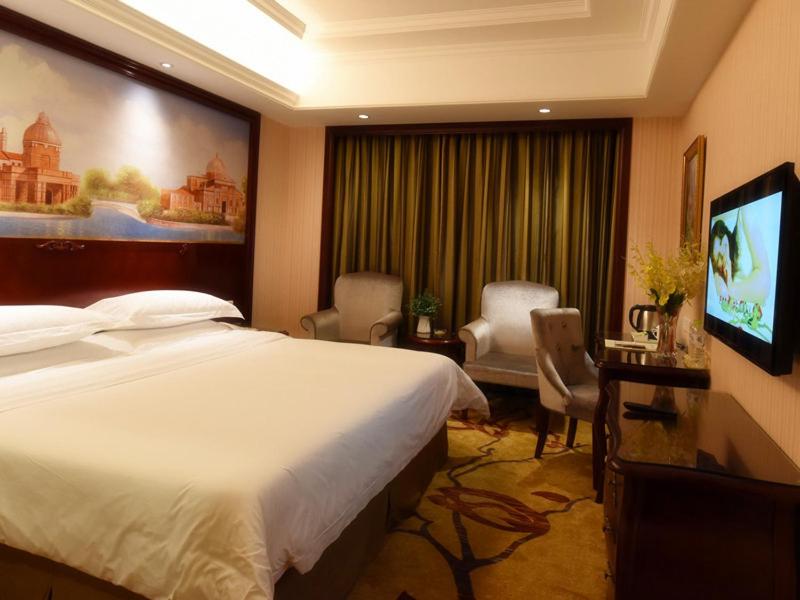 a hotel room with a bed and a flat screen tv at Vienna Hotel Loudi Chunyuan Pedestrian Street in Loudi