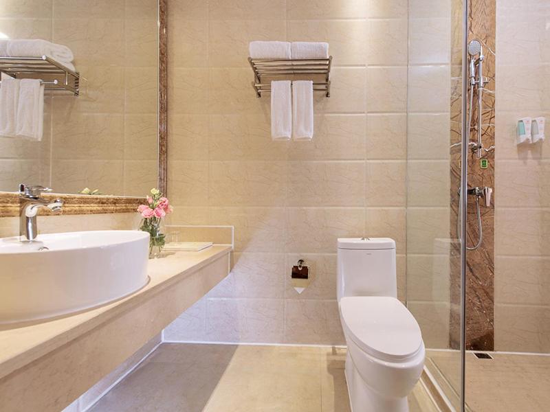 a bathroom with a toilet and a sink and a shower at Vienna Hotel Huizhou Chenjiang Avenue in Huizhou