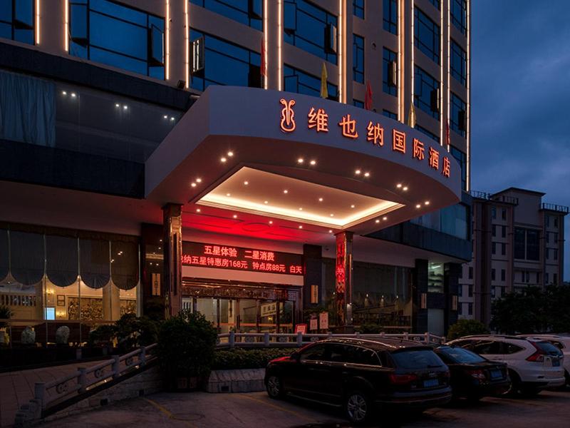 a building with a car parked in front of it at Vienna International Hotel Jieyang Jieyanglou in Jieyang