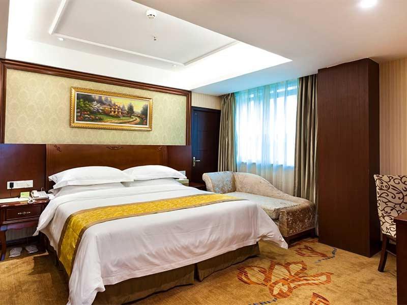 a hotel room with a large bed and a window at Vienna Hotel Nanjing Longjiang in Nanjing
