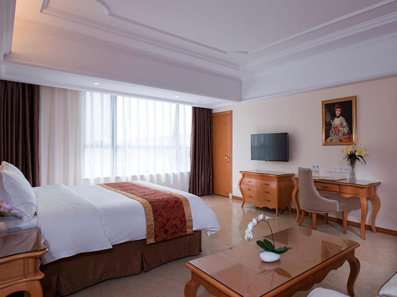 a hotel room with a bed and a desk at Vienna International Hotel Guangdong Yangjiang Zapo Travel Avenue in Lizao