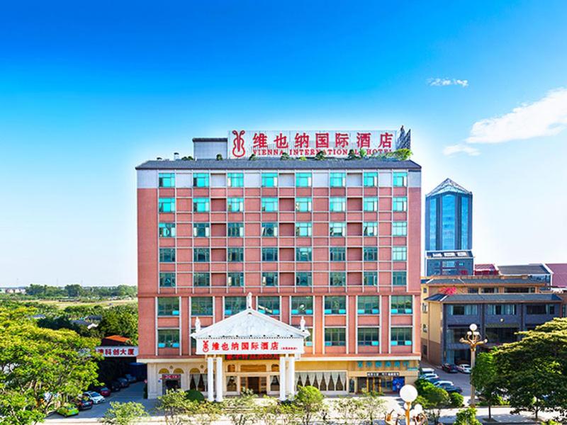 a large building with a sign on top of it at Vienna Hotel Dongguan Mayong Centre Avenue in Dongguan