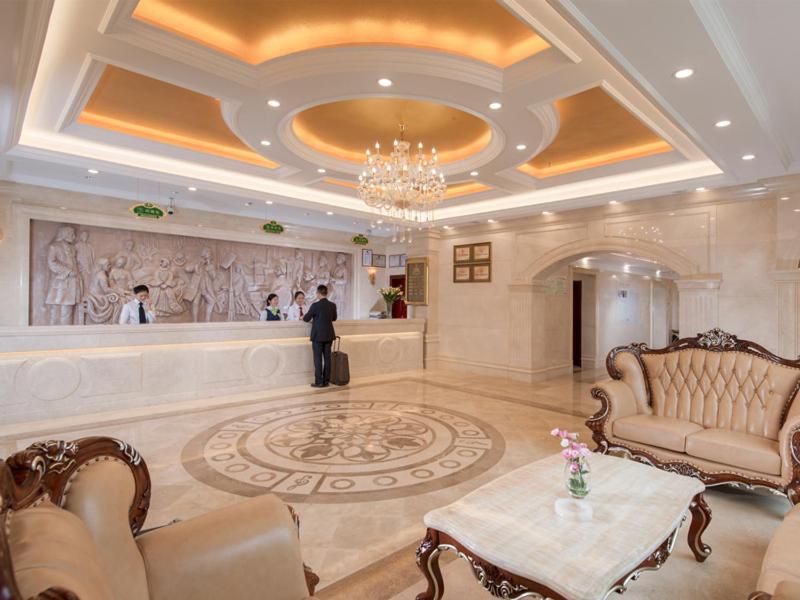 a large lobby with a man standing in the lobby at Vienna Hotel Foshan Nanhai City Square in Foshan