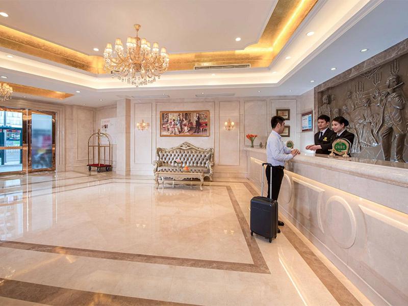 a group of people standing at a bar in a hotel lobby at Vienna Hotel Shenzhen Lo Wu Control Point in Shenzhen