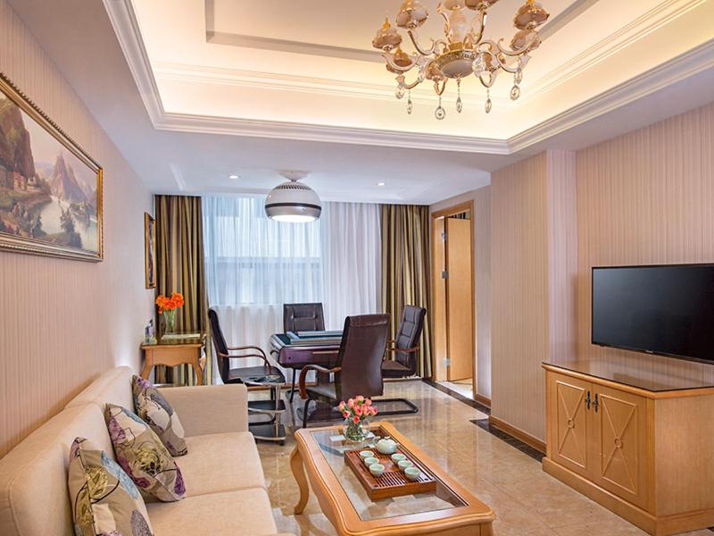 a living room with a couch and a table at Vienna Hotel Shenzhen Fuyong Subway Station in Bao'an