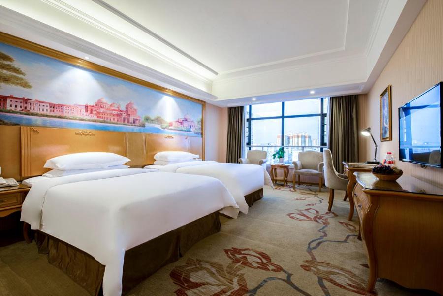 Habitación de hotel con 2 camas y TV de pantalla plana. en Vienna Hotel Qinzhou North Area Plaza en Qinzhou