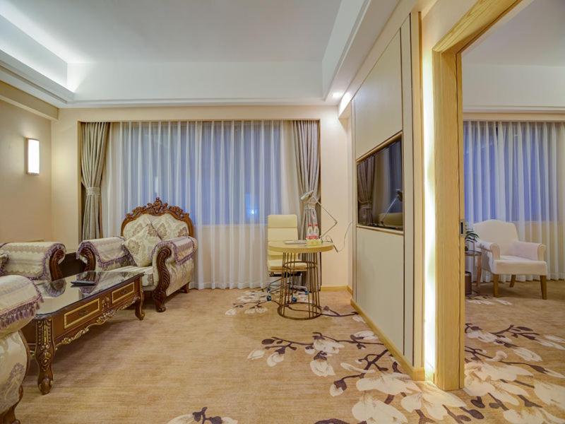 uma sala de estar com um sofá e uma televisão em Vienna Hotel Nanning Changhu Road em Nanning