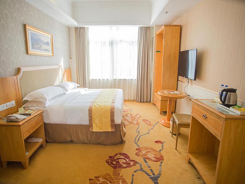 a hotel room with a bed and a television at Vienna 3 Best Hotel Huaian Qinghejiayuan in Huai'an